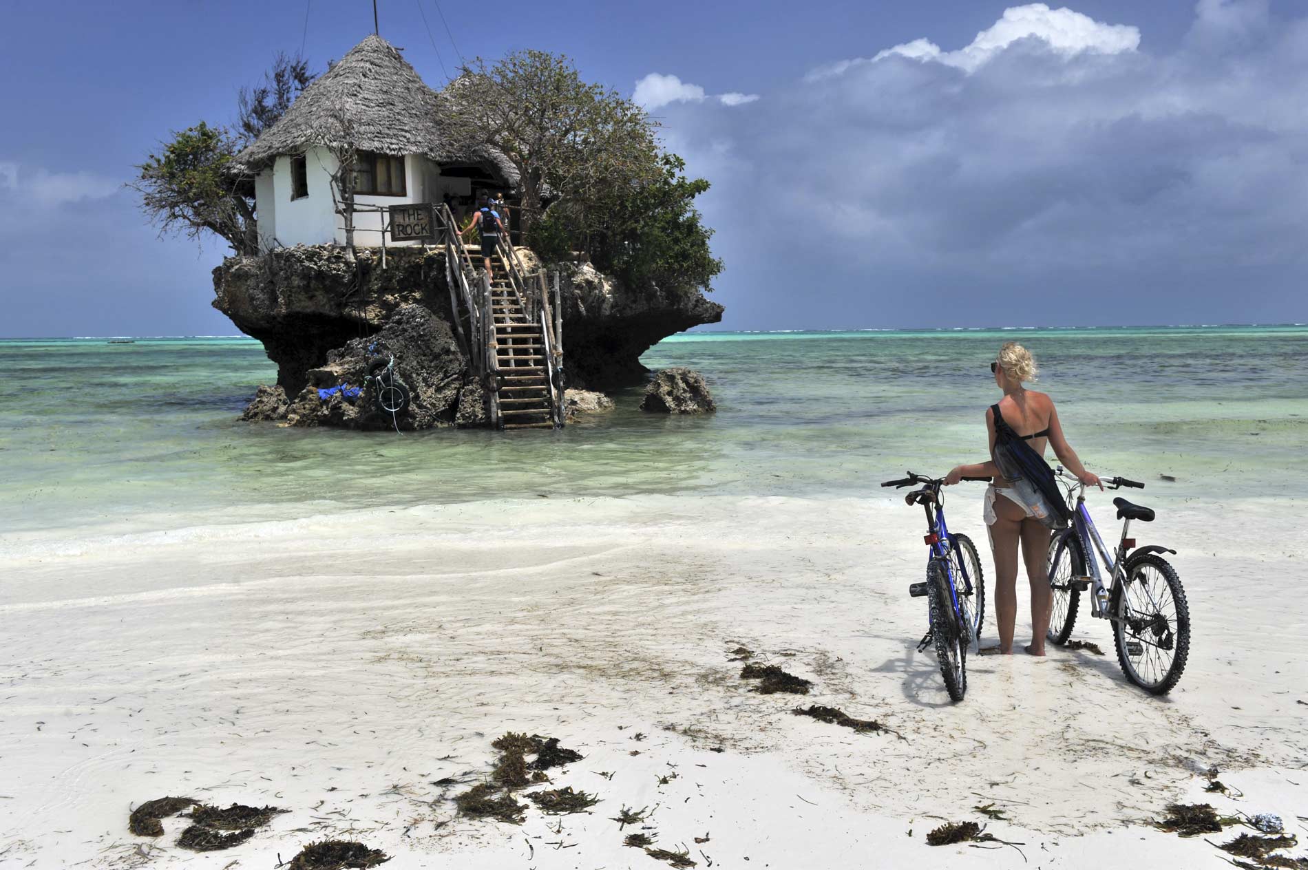 Photo couple en voyage devant la mer avec une maison sur un rocher par Christien Vicens